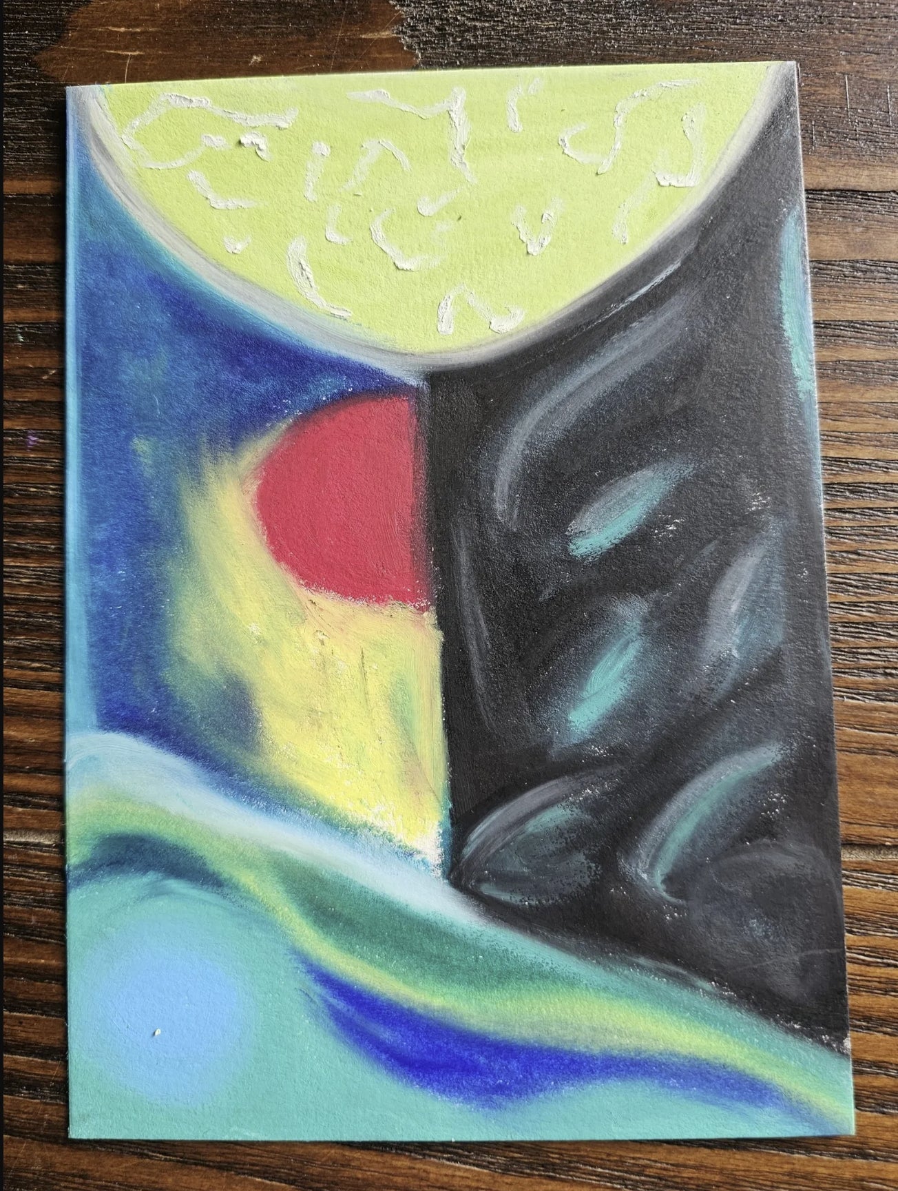 Soul's Inner Landscape" oil pastel painting by Bloodmoon resting on a wooden table surface to show its scale and physical presence.