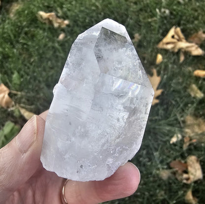 Colombian Lemurian quartz point hand-held outdoors, natural light