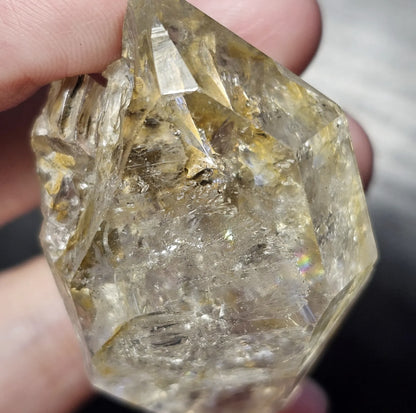 Close-up view of a rare 27-gram Herkimer Diamond quartz crystal showing its brilliant clarity, sharp termination points, and light-catching natural inclusions.