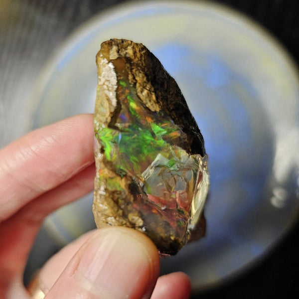 Opal stone held by a hand with a blurred background