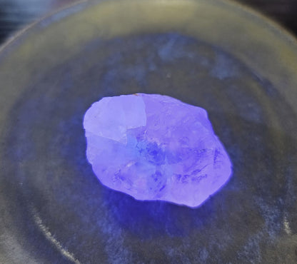 Purple crystal on a dark surface