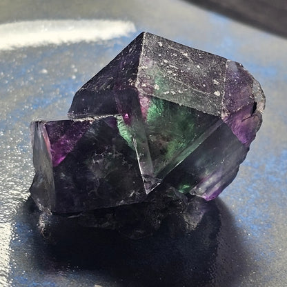 Close-up of an Alien Eye Fluorite specimen from Erongo, Namibia, showing a 1.5 inch twin crystal with deep green and purple aurora-like phantom zones.