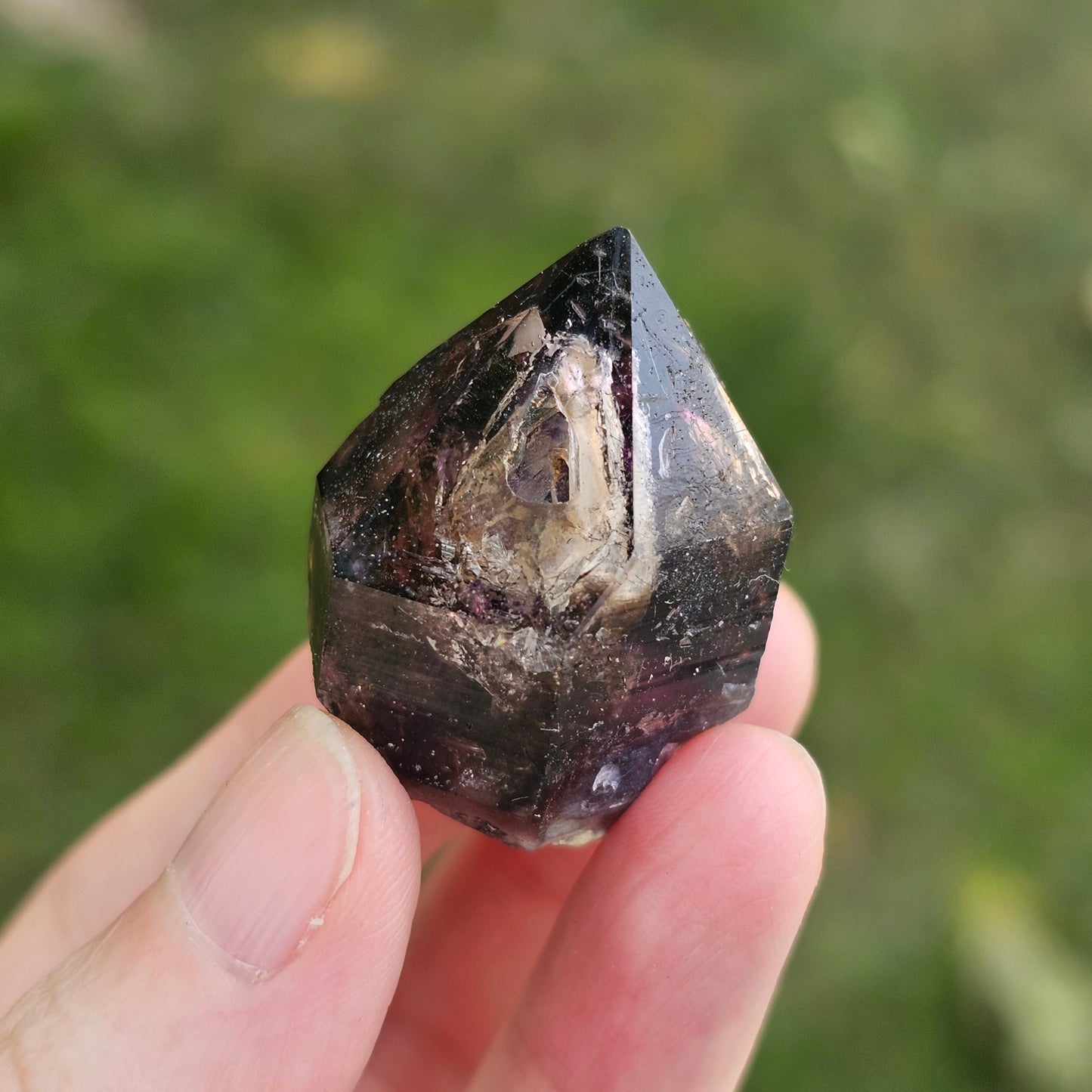 Handheld A-grade Brandberg phantom amethyst crystal with deep purple violet flame phantoms.