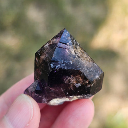 Handheld A-grade Brandberg phantom amethyst crystal with deep purple violet flame phantoms.