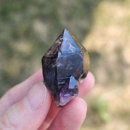 Handheld A-grade Brandberg phantom amethyst crystal with deep purple violet flame phantoms.