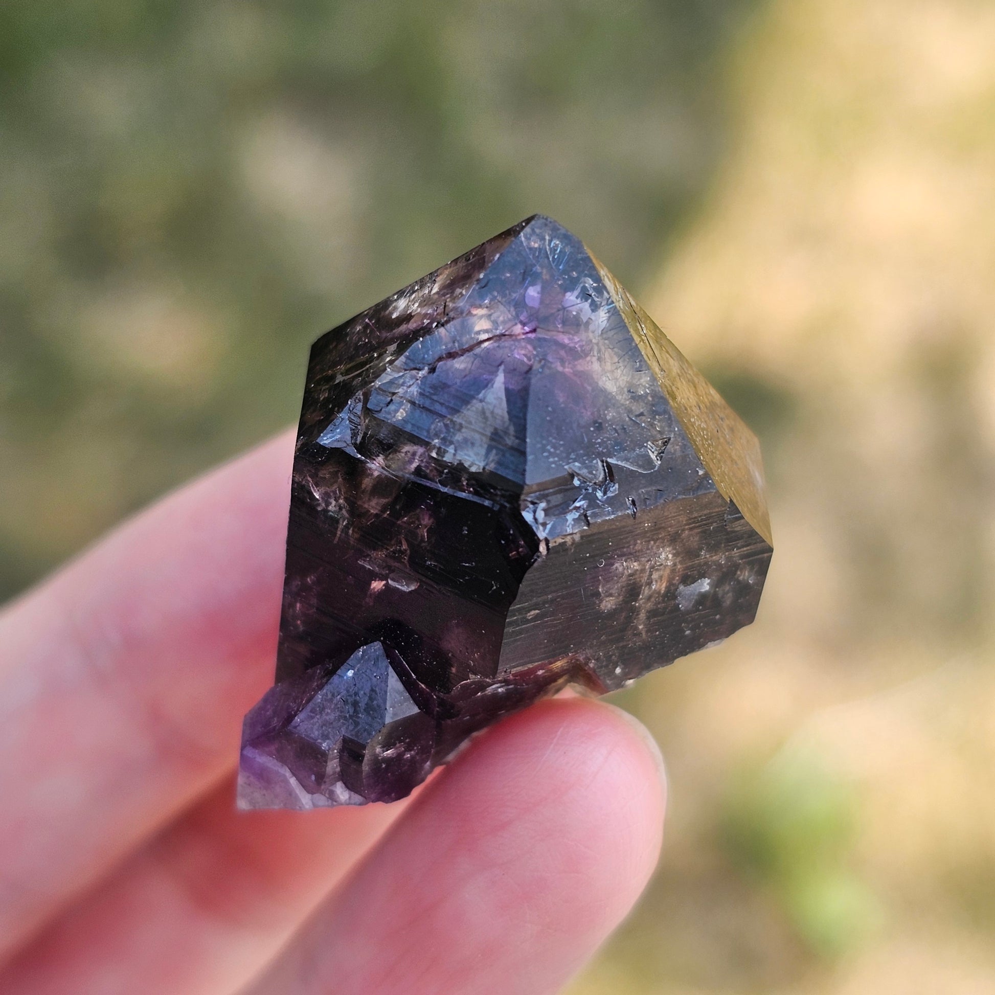 Handheld A-grade Brandberg phantom amethyst crystal with deep purple violet flame phantoms.