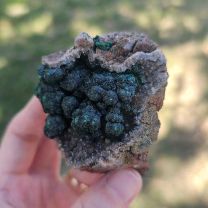 A-grade forest green Malachite balls clustered on a natural quartz-feldspar matrix from Mindigi Mine, Congo.