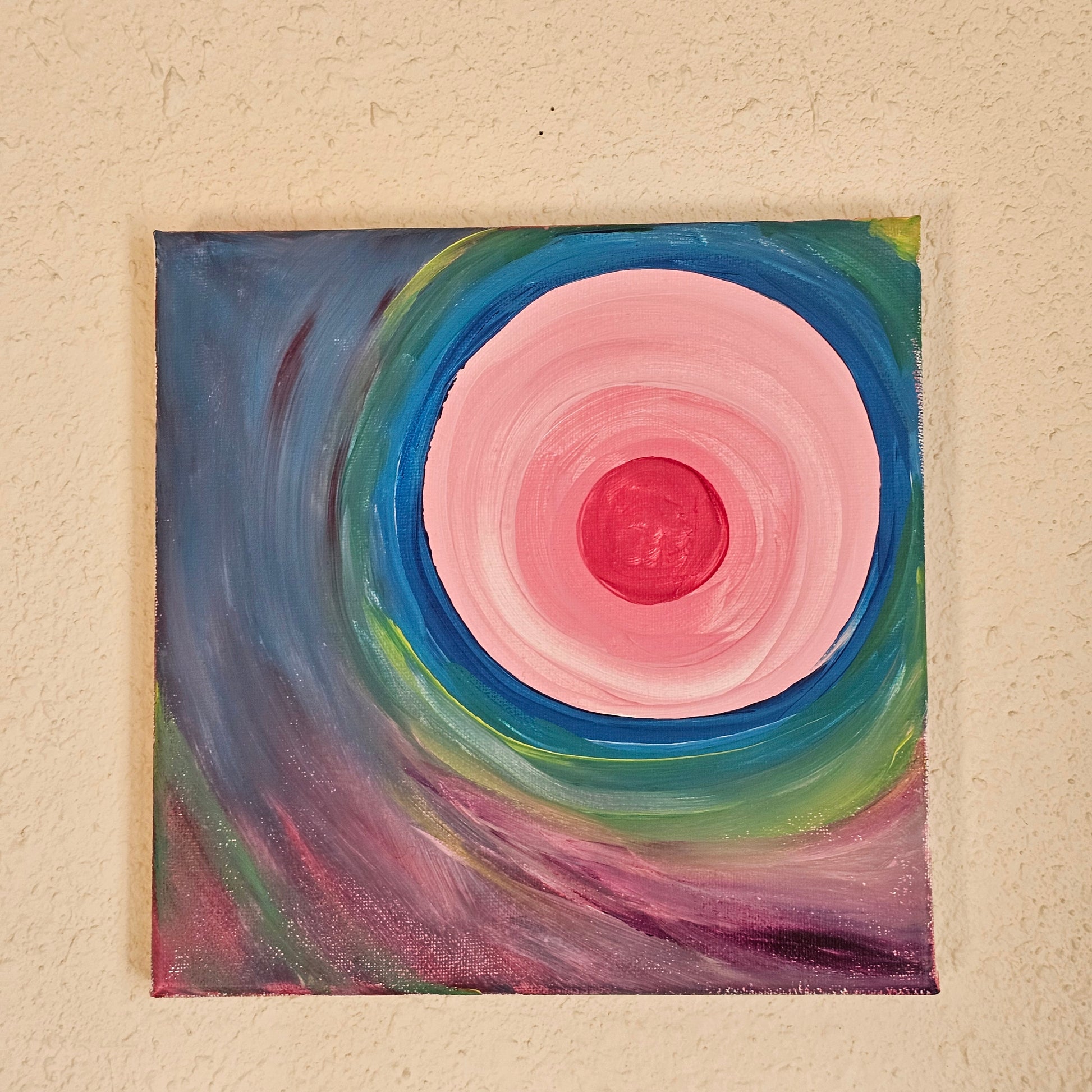 A square 8x8 inch spiritual painting displayed on a neutral wall to show the size and scale of the energy art in a home meditation space.