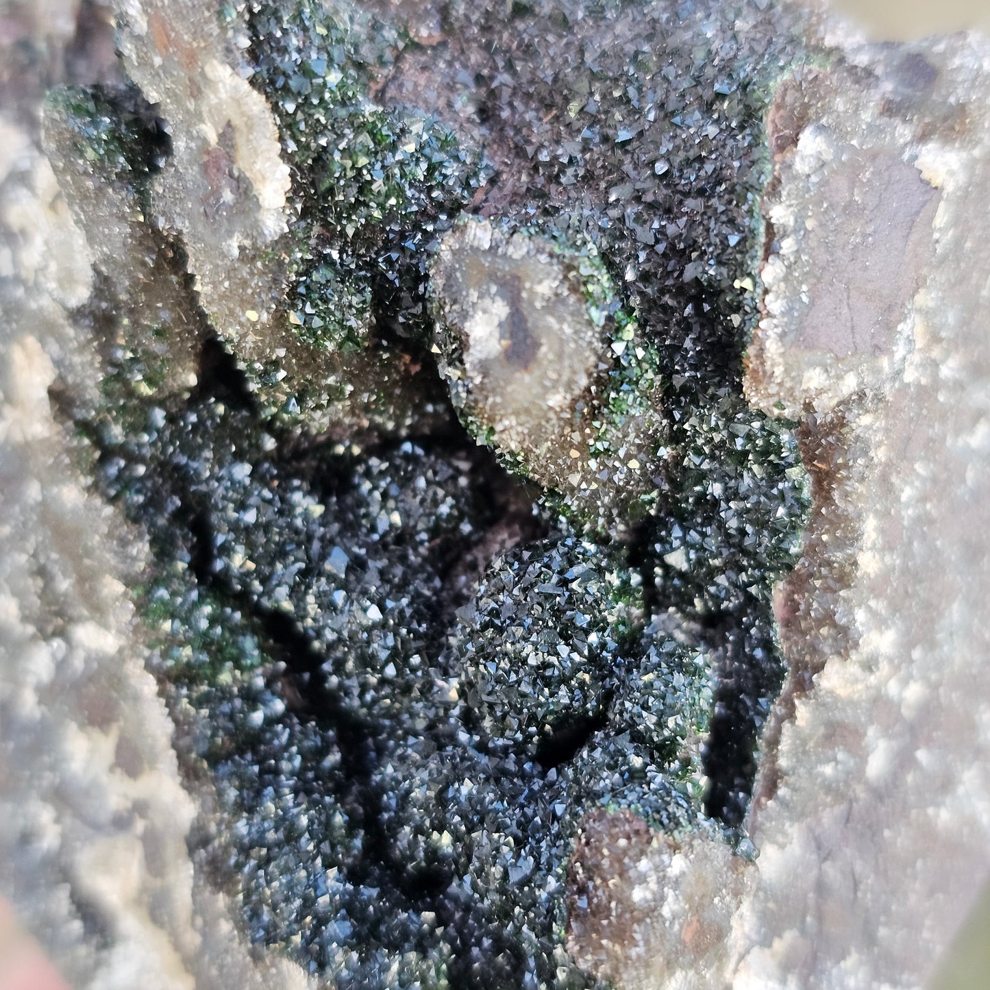 Macro close-up of sparkling white Druzy Quartz crystals over earthy green Duftite textures and grey Dolomite, highlighting the complex natural structure of the stone.