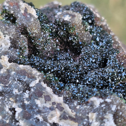 Macro close-up of sparkling white Druzy Quartz crystals over earthy green Duftite textures and grey Dolomite, highlighting the complex natural structure of the stone.