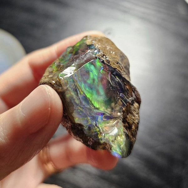 Opal stone held in a hand showing fire colors