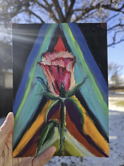 A hand holding the original Rebirth painting outdoors in natural sunlight, showing the vibrant colors and the 5x7 scale on watercolor paper.